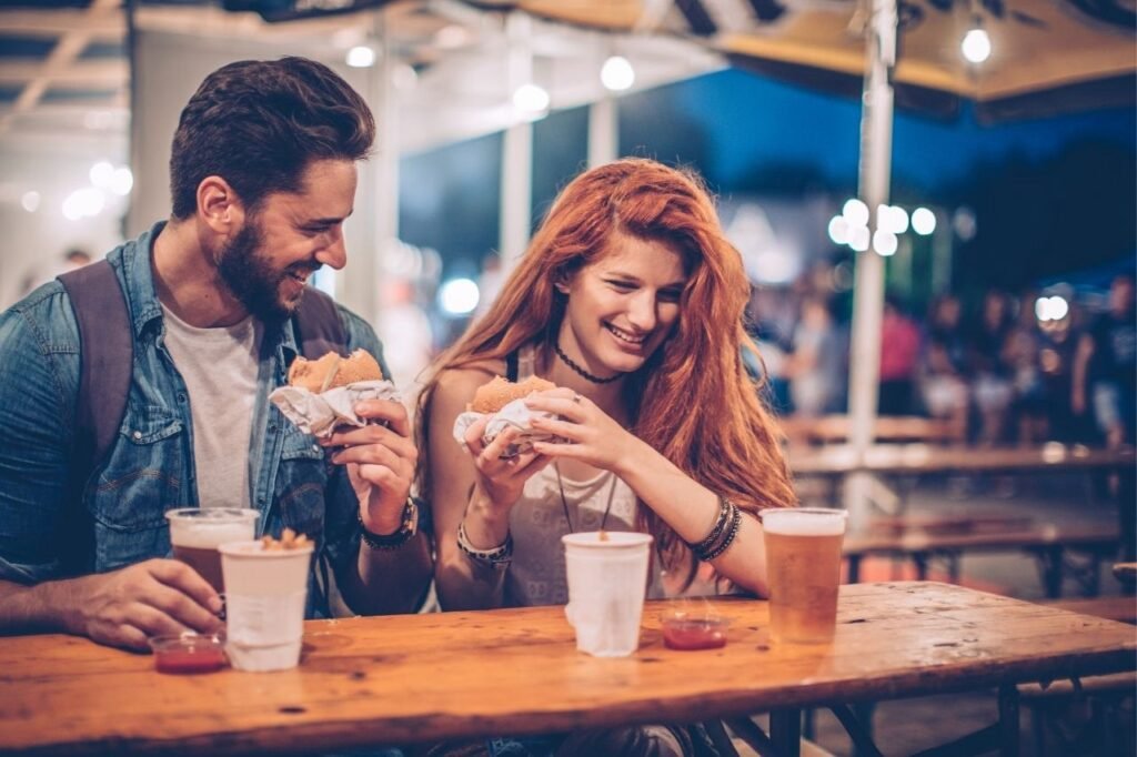 Couple laughing and having food together.