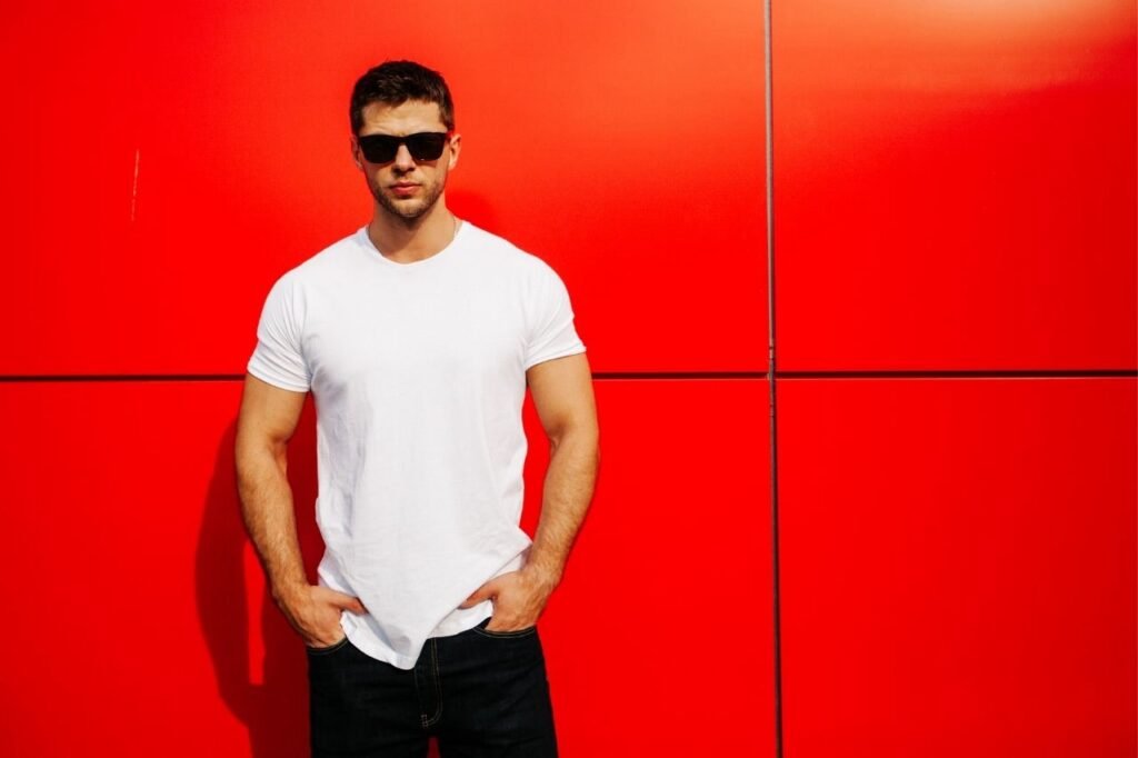 Guy standing wearing white tshirt and glasses 