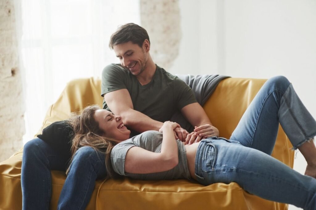 Cute couple laughing on yellow sofa