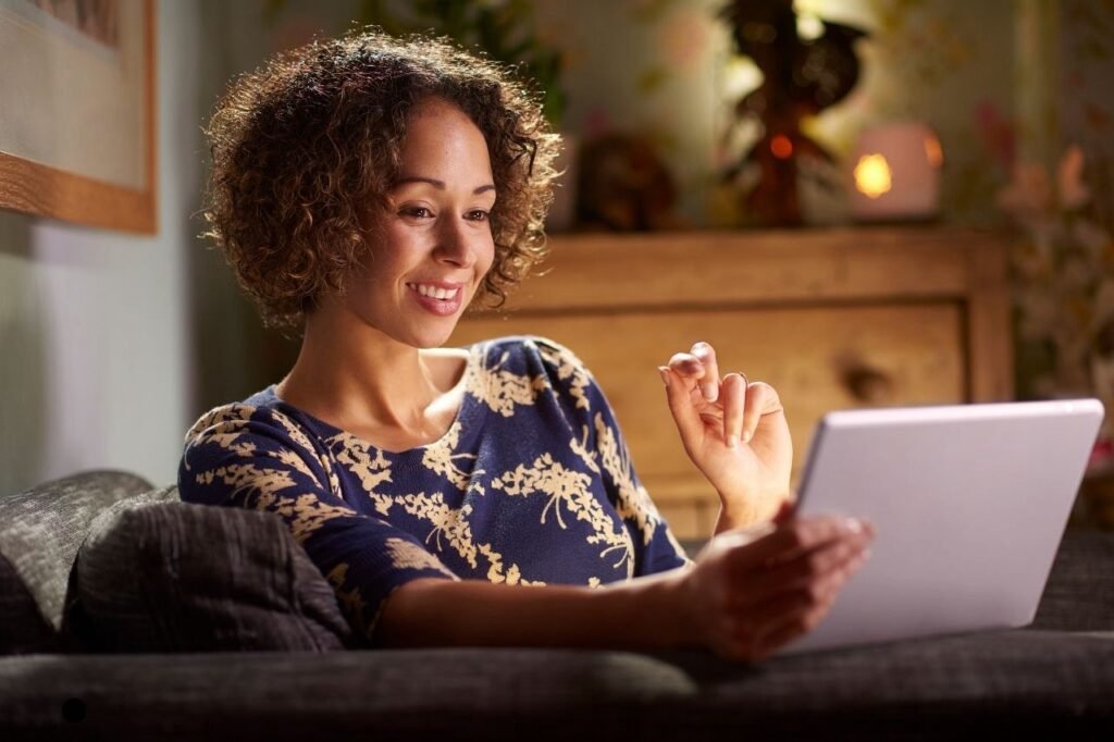 A cute curly haired girl using laptop for online dating