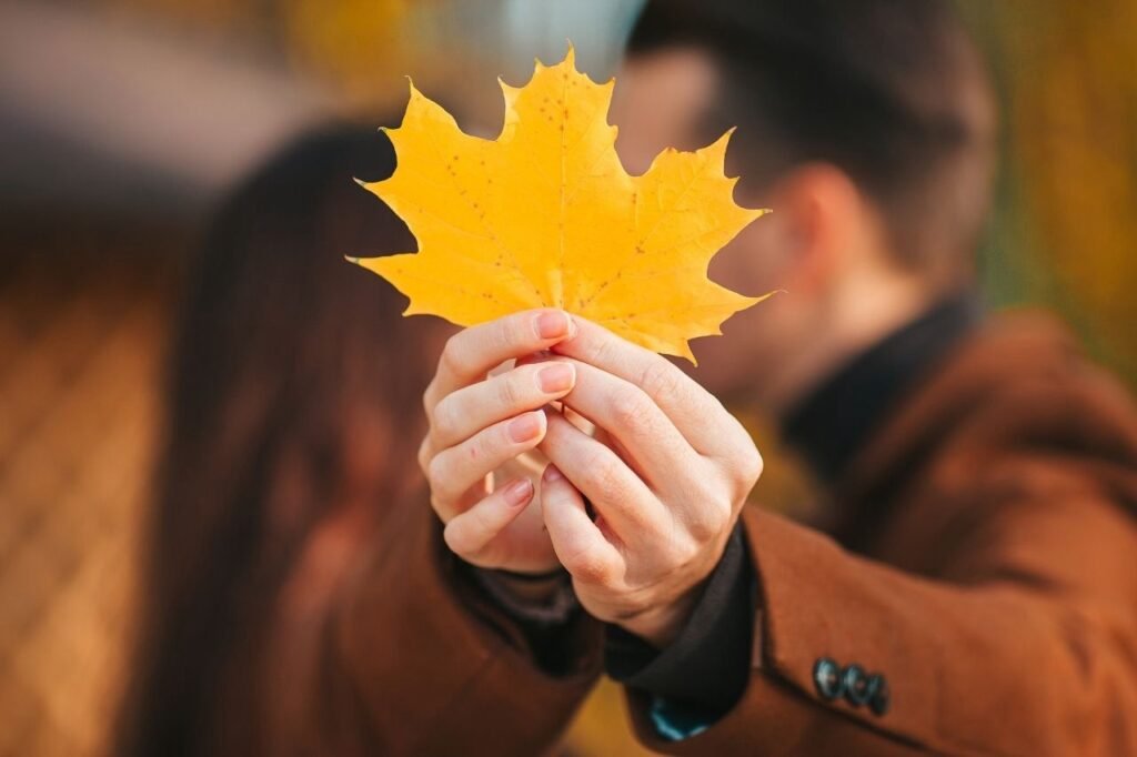 Couple kissing behind the yellow leaf